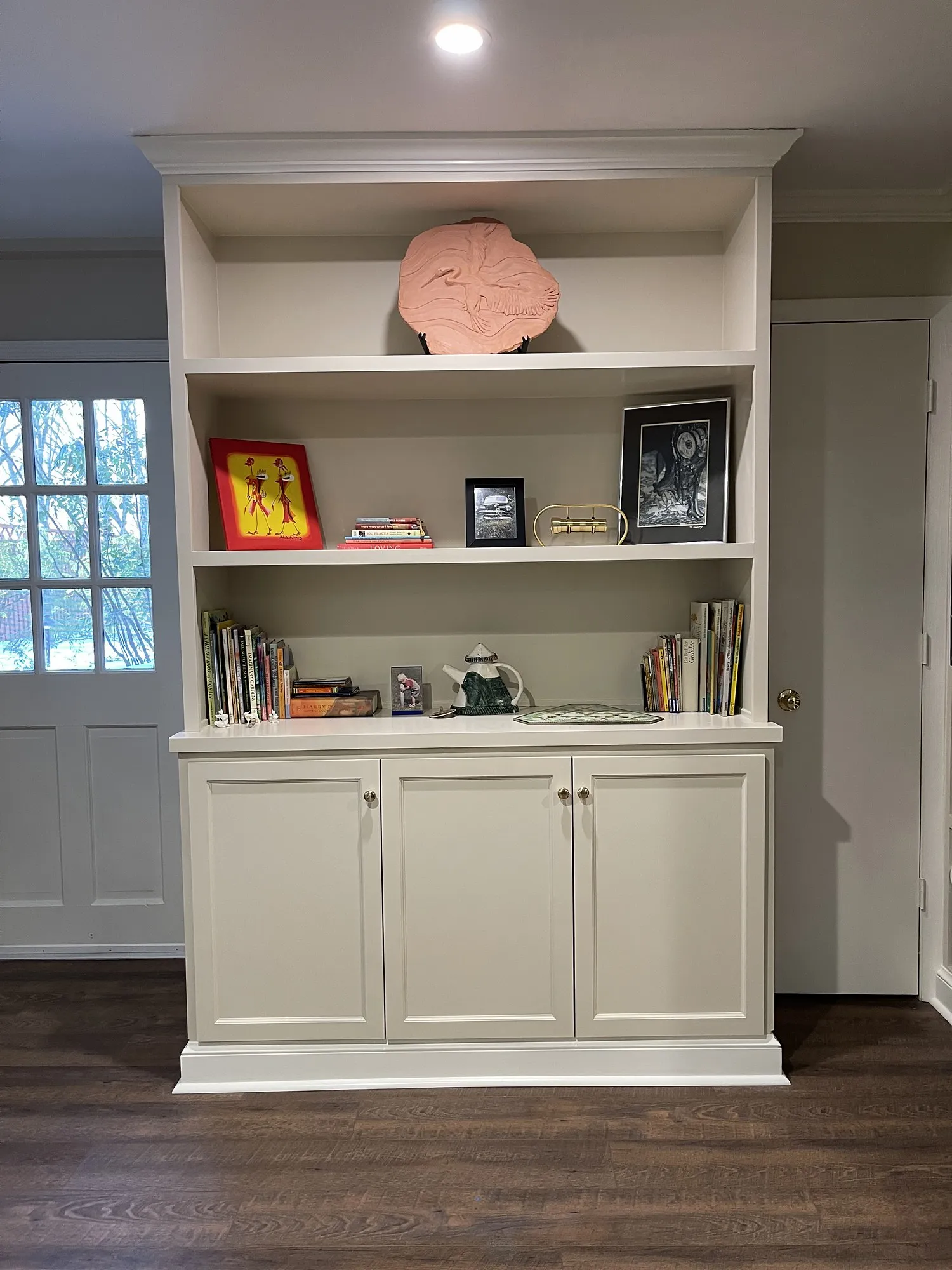 Painted built-in hutch with open shelving above and cabinet doors below, trimmed to the ceiling