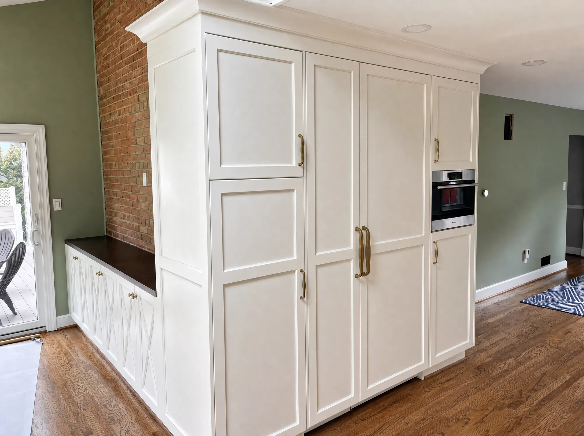 Custom white floor-to-ceiling pantry cabinetry with built-in oven by Fogg Carpentry