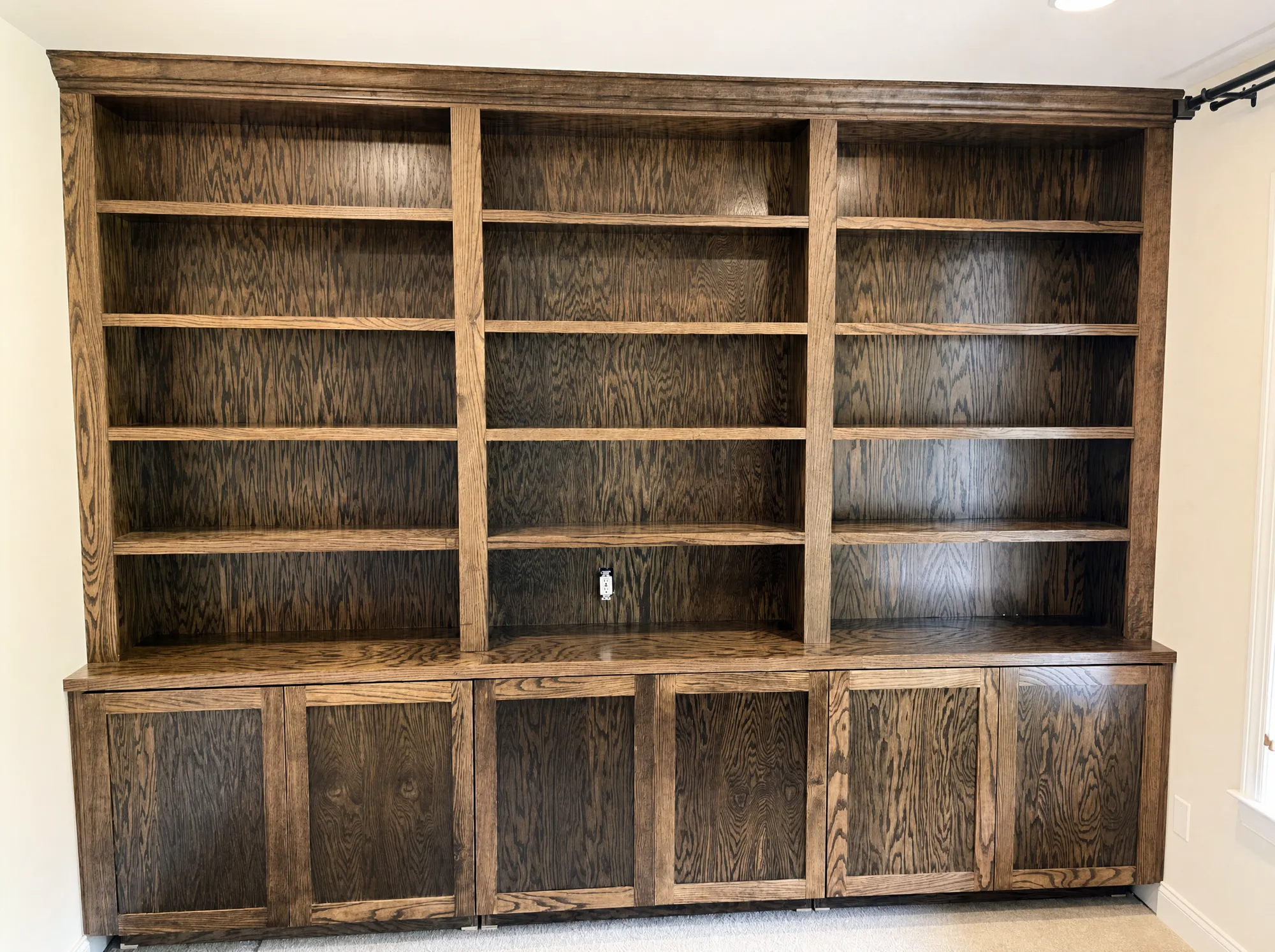 Custom dark-oak floor-to-ceiling library built-in by Fogg Carpentry