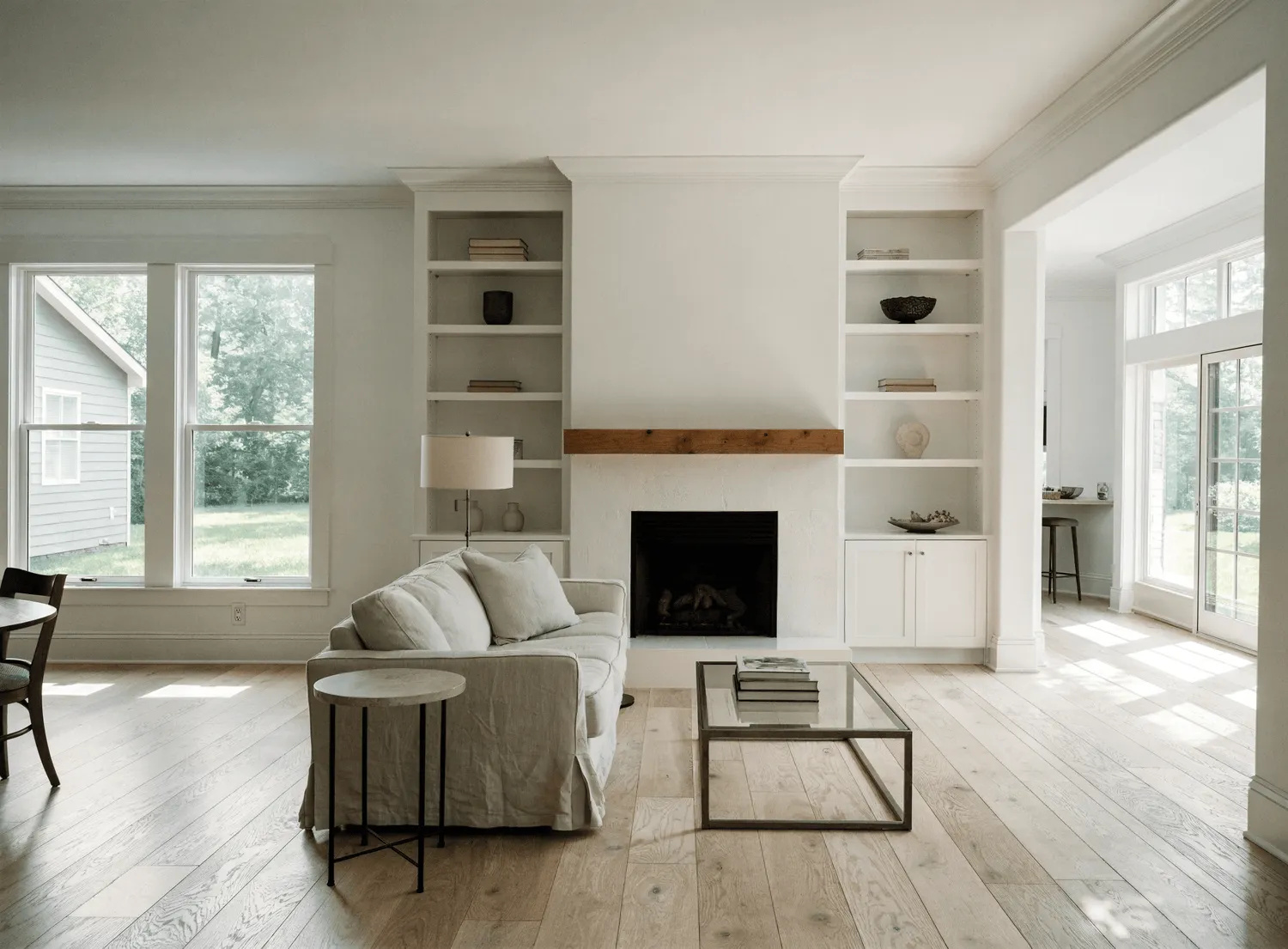 Finished living room with custom white built-ins flanking a painted fireplace by Fogg Carpentry