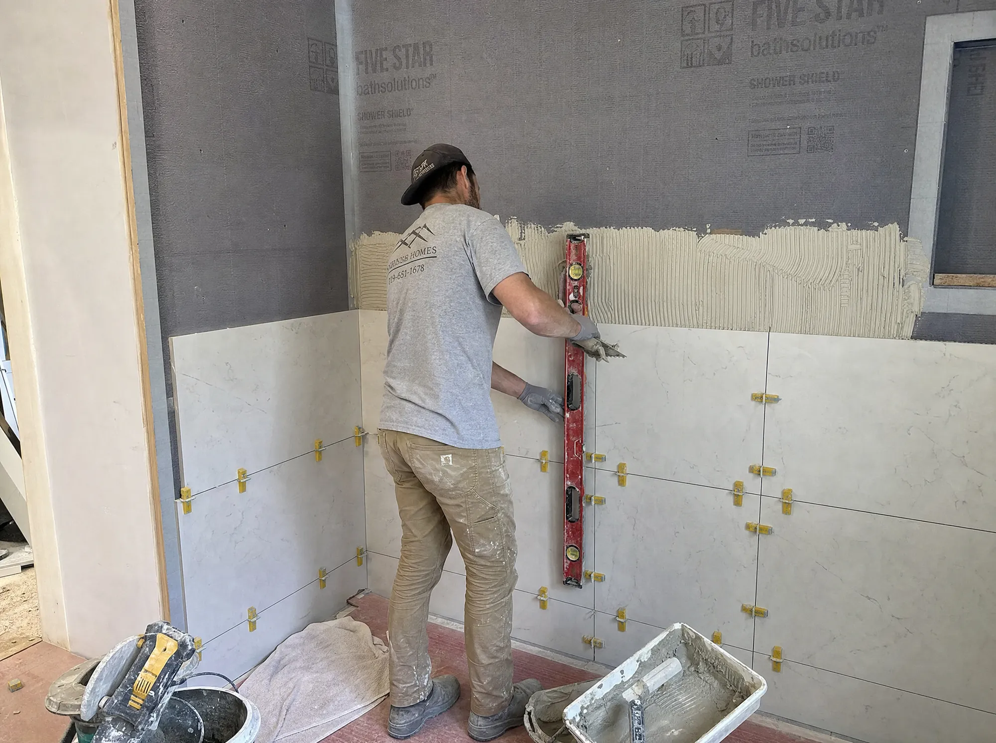 Tile being set over waterproofing on a Fogg Carpentry bathroom job site