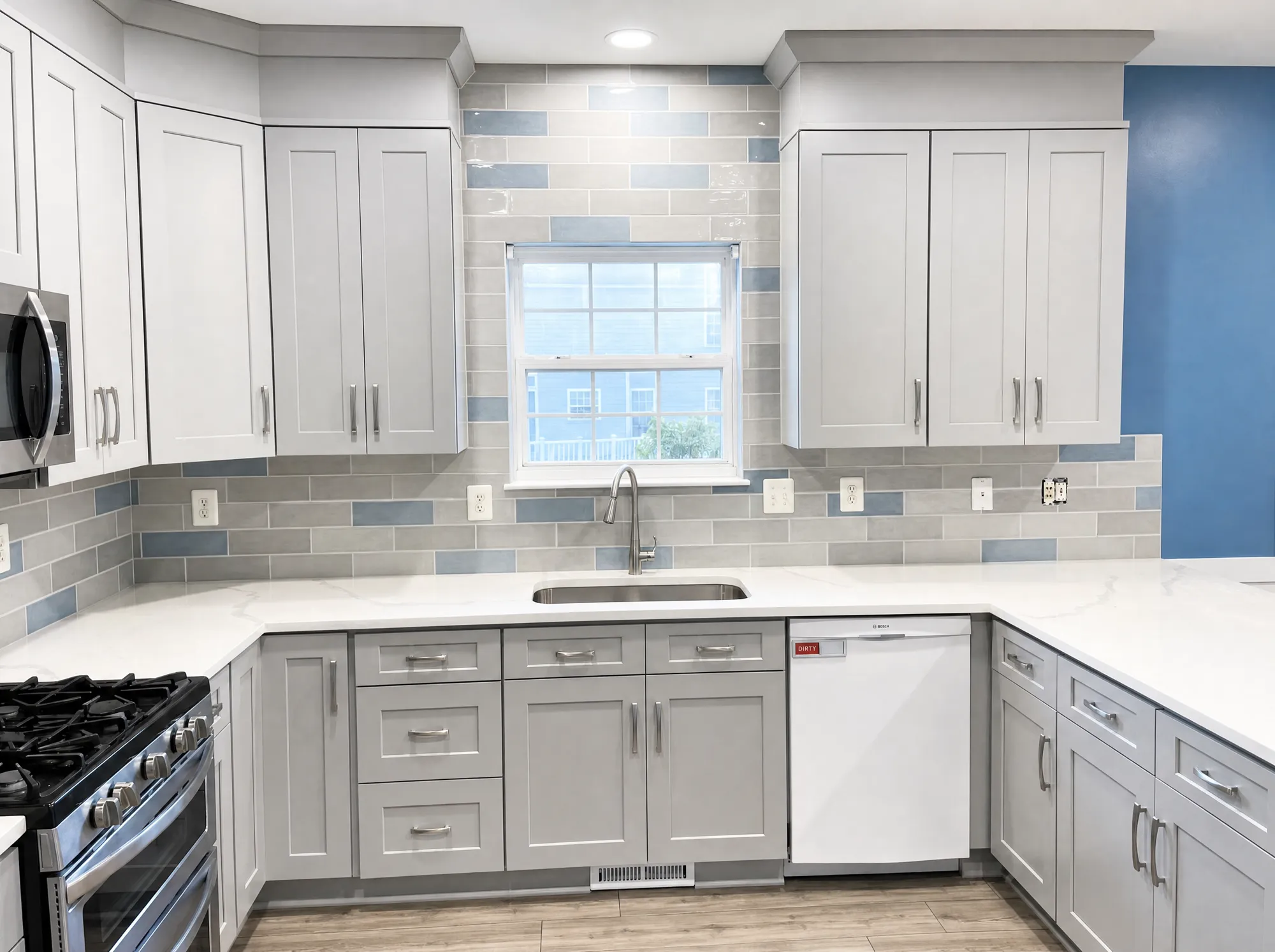 Finished grey-cabinet kitchen remodel with quartz counters
